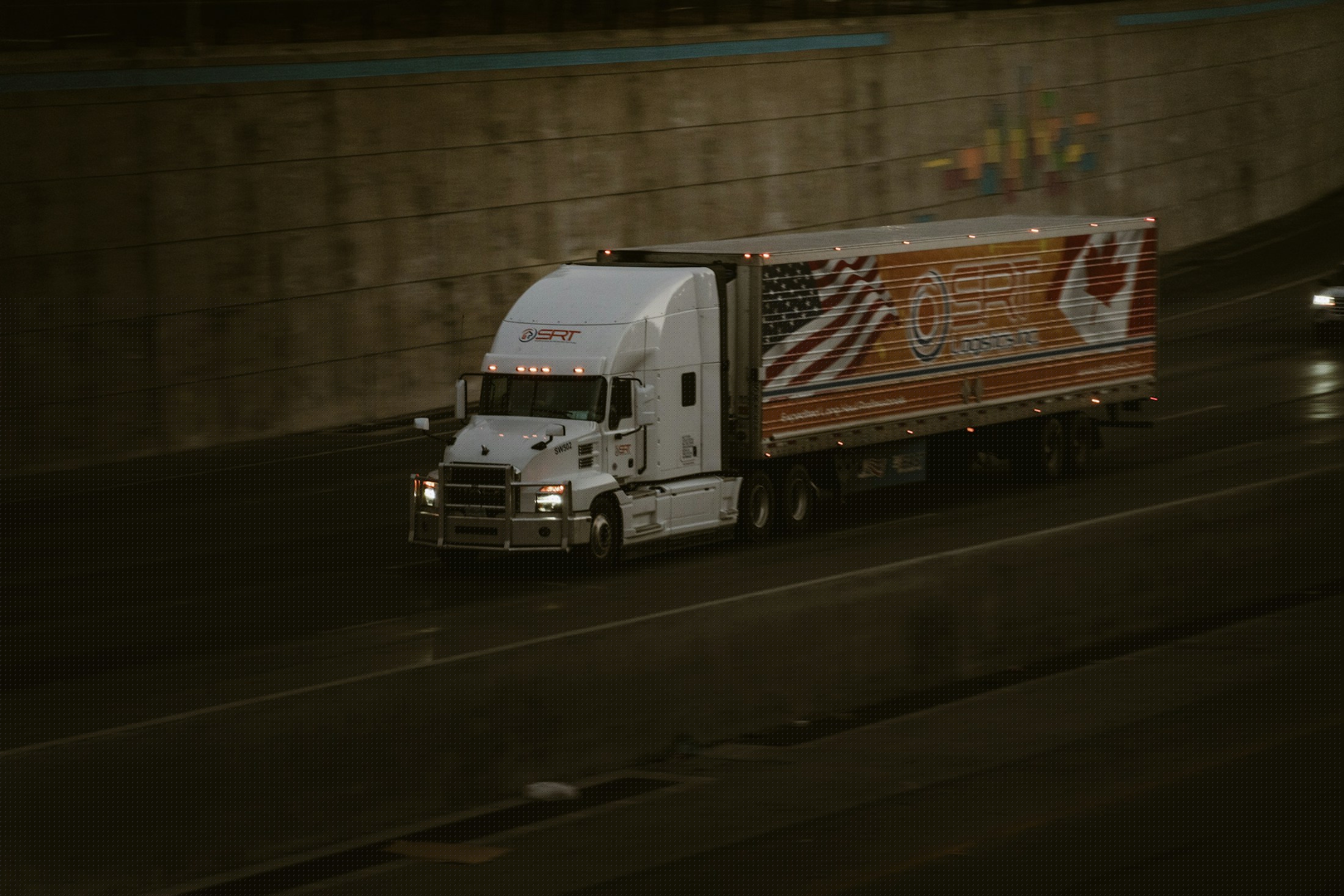 A tractor trailer carrying freight along a highway